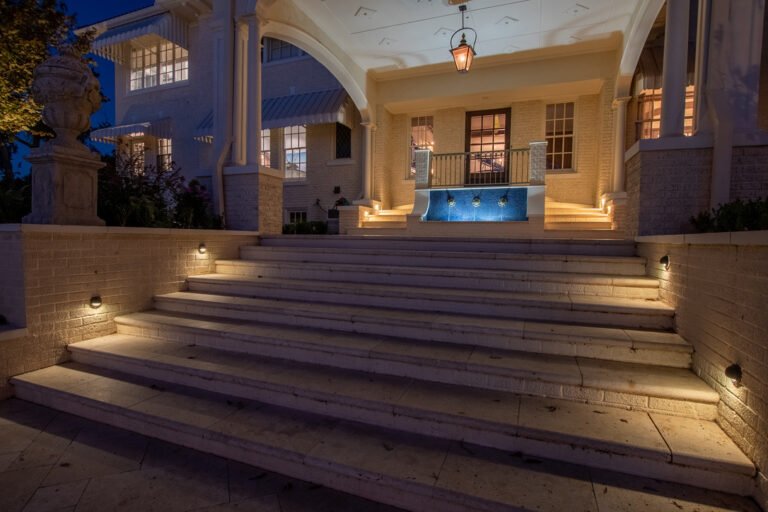 Outdoor lighting illuminating front steps and entry at night