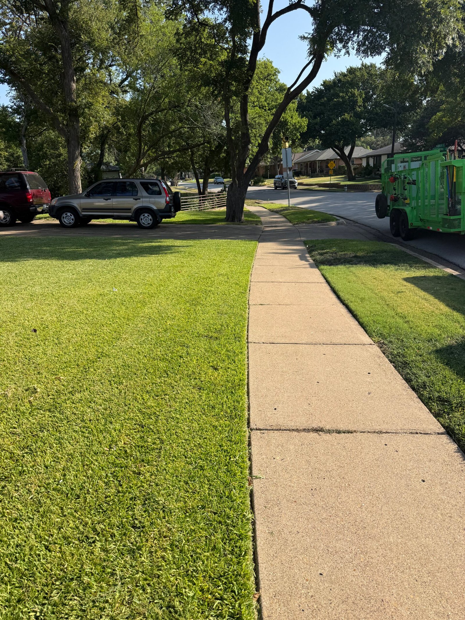 Neatly edged lawn and sidewalk with a DFW Landscape & Lighting Solutions truck