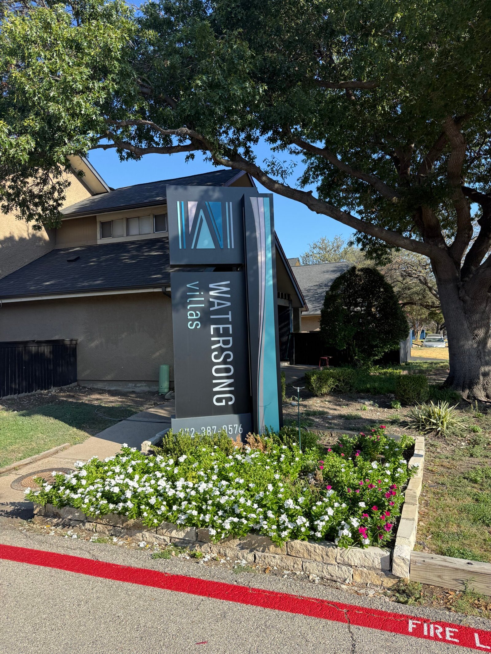 Commercial property entrance with monument sign and maintained landscape beds