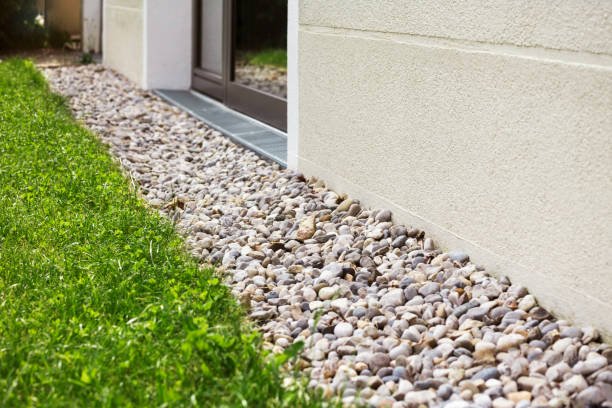 Decorative river rock border along a building foundation
